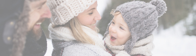 Vater und Mutter mit kleinem Kind in der Winternatur, im Schnee stehend
